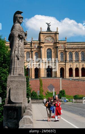 Blick auf die Statue von Pallas Athen auf der Maximilian-Brücke, die die Isar in München, Bayern, überquert. Im Hintergrund befindet sich ein Regierungsgebäude, das Bayerisher Landtag (Bayerisches Staatsparlament). Stockfoto