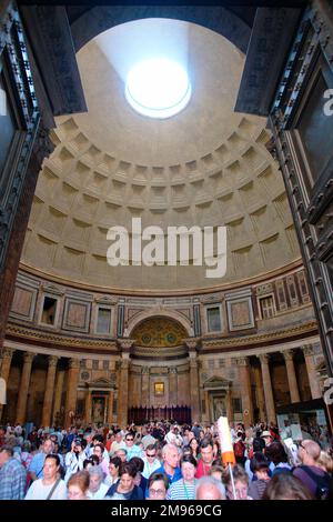 Das Innere des Pantheons in Rom, Italien, mit einer Menge Touristen unter der Kuppel. Er wurde von Marcus Agrippa als Tempel für alle Götter des antiken Roms erbaut und vom Kaiser Hadrian etwa 126 v. Chr. wiederaufgebaut. Stockfoto