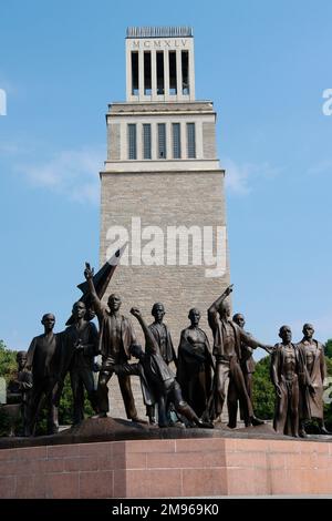 Der monumentale Glockenturm mit dem Datum MCMXLV (1945) mit der Skupturgruppe von Fritz Cremer, der den Widerstand der Insassen während ihres Leidens im ehemaligen Konzentrationslager Buchenwald, Weimar, Thüringen (Thüringen), Deutschland, repräsentiert. Stockfoto