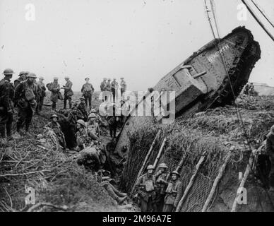 Eine Gruppe von Soldaten aus dem 1. Weltkrieg, die einen Panzer sehen, der aus Versehen in ihren Graben rutschte. Stockfoto