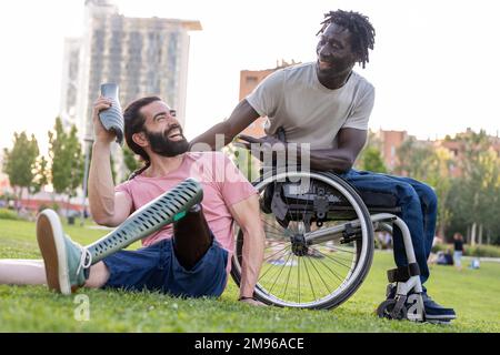 Zwei multirassische Freunde mit Behinderungen scherzen und lachen, Menschen von persönlichem und innerem Erfolg, Beispiele für Entschlossenheit und Vitalität Stockfoto