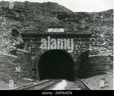 Eingang zu einem Eisenbahntunnel, der 1879 erbaut wurde und direkt unter den Hauptwerken des Oakeley Slate Quarry, Blaenau Ffestiniog, Nordwales, verläuft. Der Tunnel ist fast 2,5 km lang und das Portal, das hier zu sehen ist, besteht aus Blaenau-Schiefer. Stockfoto