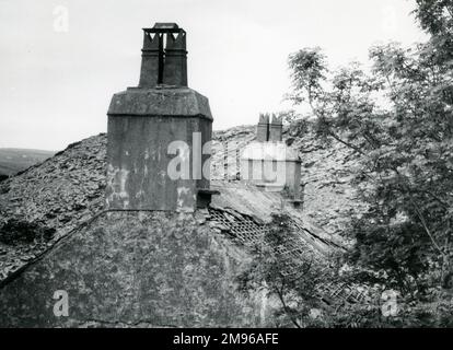 Blick auf ein heruntergekommenes Gebäude in einem Schieferbruchgebiet von Nordwales. Auf dem Dach dieses Hauses fehlen mehrere Fliesen (wahrscheinlich aus Schiefer). Stockfoto