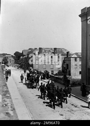 Eine Pferdekutsche eines Richters mit Polizeieskorte in New Bridge und Victoria Place, Haverfordwest, Pembrokeshire, Dyfed, Südwales. Der Richter reist von seiner Unterkunft in Picton Place zu den Asssizes. Lewis Furnishing Warehouse ist im Hintergrund zu sehen. Stockfoto