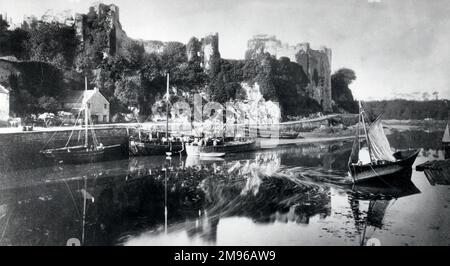 Blick auf die efeubedeckten Ruinen von Pembroke Castle in Pembrokeshire, West Wales, von der anderen Seite des Wassers aus. Das Schloss stammt aus dem 11. Jahrhundert. Seit der Aufnahme dieses Fotos wurden umfangreiche Renovierungsarbeiten durchgeführt. Stockfoto