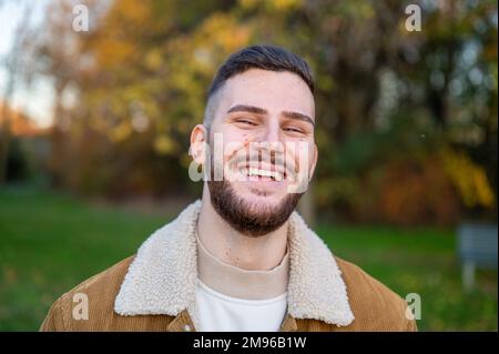 Bärtiger Mann, junger Mann mit Bart draußen in einem öffentlichen Park Stockfoto