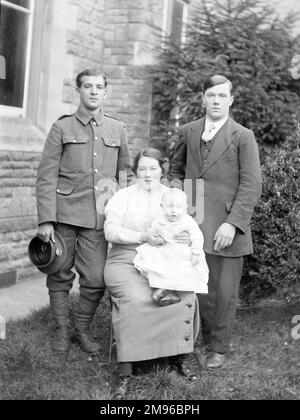 Ein Familienfoto in einem Garten, mit einer Mutter, ihrem Baby und zwei Männern, einer davon in Uniform, während des Ersten Weltkriegs. Stockfoto