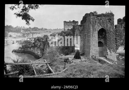 Edwardianische Frau im Schloss Chepstow, mit Blick auf den Fluss Wye in Gwent (ehemals Monmouthshire), Wales. Der Bau begann im 11. Jahrhundert und ist damit die älteste noch existierende Steinbefestigung in Großbritannien. Stockfoto