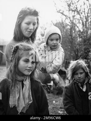 Eine Zigeunerfamilie in einem Lager in Surrey -- eine junge Mutter und ihre drei Kinder. Stockfoto