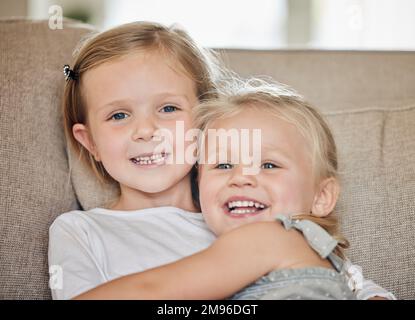 So etwas wie Spaß für die ganze Familie gibt es nicht. Zwei Schwestern zusammen auf dem Sofa zu Hause. Stockfoto