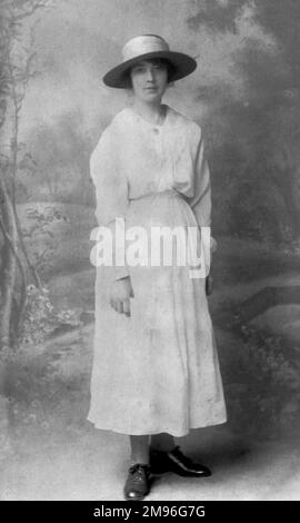 Elegante Frau in einem langen weißen Kleid und einem Hut mit breiter Krempe Stockfoto