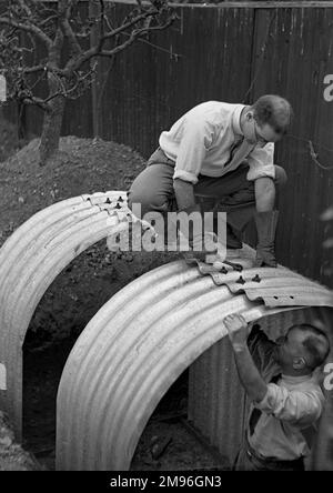 Zwei Männer bauten zu Beginn des Zweiten Weltkriegs einen Unterschlupf in einem Garten. Stockfoto