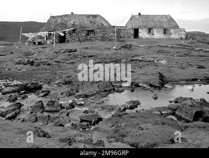 Zwei rustikale Hütten in einer düsteren Landschaft, mit Wäscheleinen an einer Wäscheleine, in Timsgarry, Uig, Isle of Lewis, Äußeren Hebriden, Schottland. Stockfoto