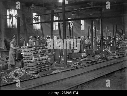 WW1 - eine große Gruppe von Arbeiterinnen in einer Fabrik, die Bleischrapnell für den Einsatz in hochexplosiven Artillerieschalen herstellt. Stockfoto