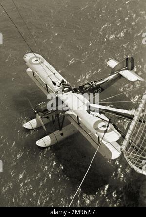 Luftaufnahme eines Wasserflugzeugs, das auf dem Wasser schwimmt, kurz davor, einen Haken von einem Kran daran zu befestigen. Stockfoto