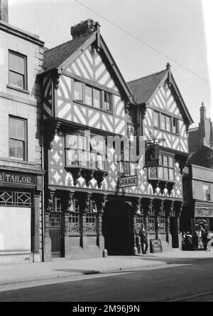 Straßenszene an einem unbekannten Ort, mit dem Nag's Head Hotel im Tudor-Stil, einem alten Gasthaus. Stockfoto