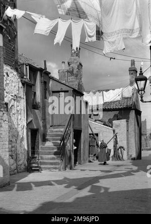 Eine Straßenszene in Edinburgh, in der zwei ältere Nachbarn am Waschtag in der Sonne plaudern. Stockfoto