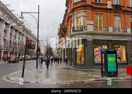 Blick auf die Oxford Street mit Leuten, die im Regen im Zentrum von London, Großbritannien, einkaufen Stockfoto