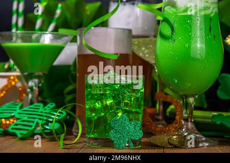 Hintergrund der Bar St. Patrick's Day. Verschiedene goldene, grüne Biergläser, verschiedene Cocktails und Getränke, mit St. Patrick's Day Party Dekor und Stockfoto