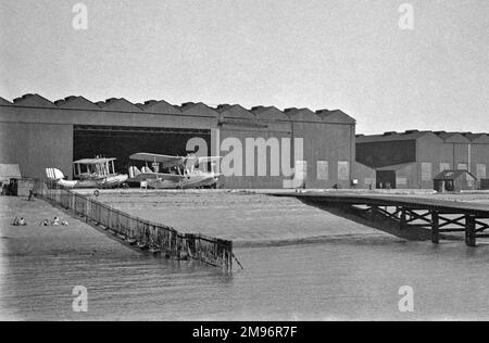 RAF Felixstowe, Marine Aircraft Experimental Establishment, Hangar und Helling mit Doppeldeckern am Wasserrand (ein Supermarine Southampton auf der linken Seite und ein Saunders Roe A.27 auf der rechten Seite). Stockfoto