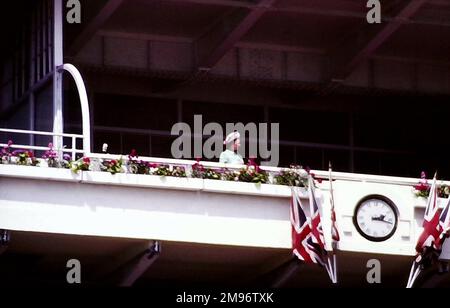 Ihre Majestät Königin Elisabeth II. Erscheint allein in der königlichen Box beim Epsom Derby, 1977. The Derby Stakes, auch bekannt als Epsom Derby oder Derby, findet auf dem Epsom Downs Race Course, Epsom, Surrey, England, UK statt. Archivfoto. Stockfoto