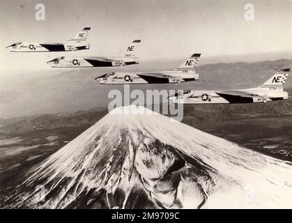 Vier Kreuzritter der Serie Vought F8U-1 von VF-211 auf der USS Midway fliegen über den Berg Fujiyama in Japan. Stockfoto