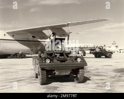 Ein Panzerwagen von Ferret in Belize mit einem kurzen RAF SC-5 Belfast CMk1 im Hintergrund. 1975. Stockfoto