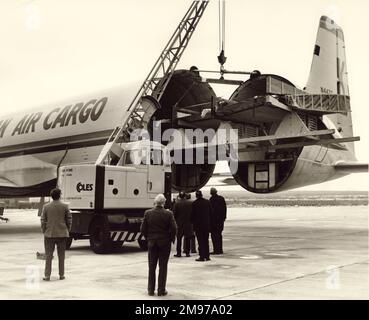 Der Hafenflügel der BAC One-Eleven von Mohawk Airlines wird auf die einzige Canadair CL-44-O, N447T, der Transmeridian Air Cargo auf der Rampe von Wisley verladen. Stockfoto