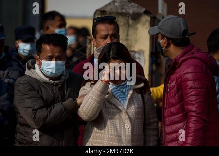 Pokhara, Nepal. 17. Januar 2023. Die Angehörigen der Opfer eines Flugzeugabsturzes der Yeti Airlines warten, bis die Überreste ihrer Geliebten auf Lastwagen in Pokhara, Nepal, am 17. Januar 2023 geladen werden. Die Überreste der Opfer werden später nach Kathmandu, Hauptstadt Nepals, überführt. Ein Flugzeug der Yeti Airlines stürzte am Sonntag in die Schlucht des Seti River in der Nähe der Stadt Pokhara ab, als es von Kathmandu nach Pokhara flog, mit 68 Passagieren und vier Besatzungsmitgliedern an Bord, und 69 Leichen waren bis Montagabend geborgen worden. Kredit: Xinhua/Alamy Live News Stockfoto