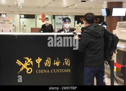 (230117) -- PEKING, 17. Januar 2023 (Xinhua) -- Ein Zollbeamter überprüft den Gesundheitscode eines Passagiers, der den Flug CZ309 von Peking nach Hongkong am Peking Daxing International Airport in Peking, Hauptstadt von China, am 17. Januar 2023 nimmt. Mit dem Start des CZ309-Fluges nach Hongkong nahm der Internationale Flughafen Peking Daxing am Dienstag den Betrieb internationaler Passagierflüge wieder auf, nachdem China seine Politik zur Prävention und Bekämpfung von COVID-19-Epidemien kontinuierlich optimiert hatte. Der Peking Daxing International Airport ist Pekings neuester Flughafen und wurde am Septembe in Betrieb genommen Stockfoto