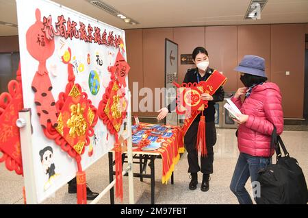 (230117) -- PEKING, 17. Januar 2023 (Xinhua) -- Ein Passagier (R) wird angeboten, kleine Geschenke zu sammeln, bevor er den Flug CZ309 am Peking Daxing International Airport in Peking, Hauptstadt von China, am 17. Januar 2023 antritt. Mit dem Start des CZ309-Fluges nach Hongkong nahm der Internationale Flughafen Peking Daxing am Dienstag den Betrieb internationaler Passagierflüge wieder auf, nachdem China seine Politik zur Prävention und Bekämpfung von COVID-19-Epidemien kontinuierlich optimiert hatte. Als neuester Flughafen Pekings wurde der Peking Daxing International Airport am 25. September 2019 in Betrieb genommen. Ab dem 14. März 2020 ist die Ai Stockfoto