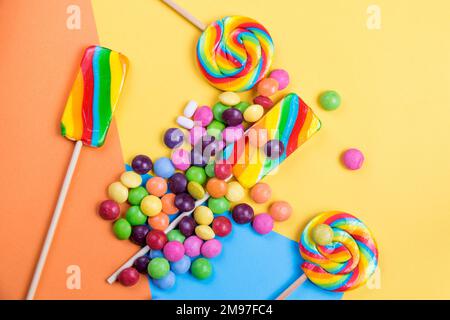 Bunte Süßigkeiten, Lutscher auf dem farbigen Hintergrund Stockfoto