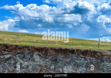 Freilandfarm elektrische Drahtzäune auf Zlatibor Hügeln mit weißen Wolken im Hintergrund, selektiver Fokus Stockfoto