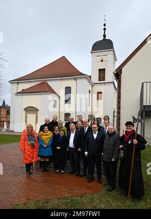 17. Januar 2023, Brandenburg, Altlandsberg: Dietmar Woidke (M), Ministerpräsident von Brandenburg, und neben ihm Gernot Schmidt (beide SPD), Bezirksverwalter des Bezirks Märkisch-Oderland, stehen Sie Seite an Seite für ein Gruppenfoto vor der Burgkirche vor dem Beginn der gemeinsamen Sitzung des Kabinetts und der Bezirksleitung. Rechts steht ein Mann, verkleidet als historischer Nachtwächter von Altlandsberg. Im Rahmen der Reihe „Cabinet on Site“ wurden unter anderem die regionale Entwicklung, der Ausbau der Schieneninfrastruktur und die Wasserversorgung im Bezirk erörtert. Foto: Soeren Stache Stockfoto