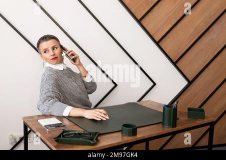 Geschäftsfrau mit kurzer Frisur, die im Büro telefoniert Stockfoto