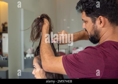 Goiania, Goiás, Brasilien – 10. Januar 2023: Detail eines Friseurs, der die Haarsträhne eines Kunden trennt. Stockfoto