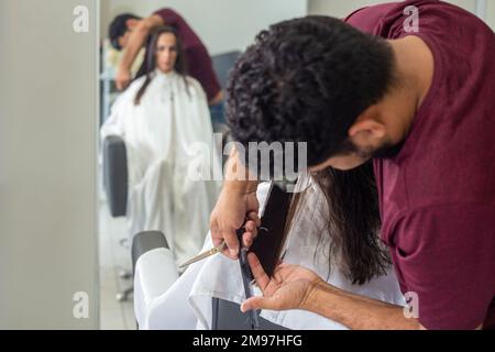 Goiania, Goiás, Brasilien – 10. Januar 2023: Detail eines Friseurs, der die Haarsträhne eines Kunden trennt. Stockfoto