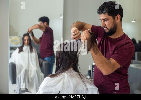 Goiania, Goiás, Brasilien – 10. Januar 2023: Detail eines Friseurs, der die Haarsträhne eines Kunden trennt. Stockfoto