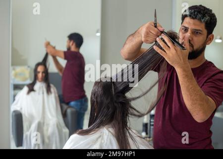 Goiania, Goiás, Brasilien – 10. Januar 2023: Detail eines Friseurs, der die Haarsträhne eines Kunden trennt. Stockfoto