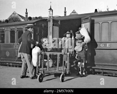 Pfadfinder und andere, die in einen Eisenbahnzug einsteigen. Stockfoto