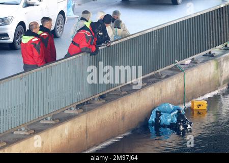 Hamburg, Deutschland. 17. Januar 2023. Hamburger Polizeitaucher sind an einem Kanal in Wilhelmsburg im Dienst. Polizeitaucher setzten ihre Suche nach Körperteilen im Ernst-August-Kanal in Hamburg-Wilhelmsburg am Dienstagmorgen fort. Ein Fischer hatte dort am Sonntag eine Tasche mit menschlichen Überresten entdeckt. Kredit: Bodo Marks/Bodo Marks/dpa/Alamy Live News Stockfoto