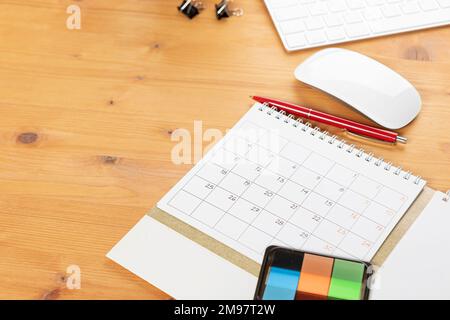 Kalender- und Terminplanerinnerungen, arbeiten Sie online von zu Hause aus. Tischkalender mit Schreibwaren und Bleistift, Tastatur. Markieren Sie eine Urlaubsreise oder Pläne in einem Durchm Stockfoto