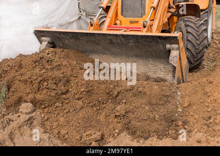 Bagger oder Bulldozer Schaufel flacht den Boden oder Straße in der Industriezone oder Baustelle. Stockfoto