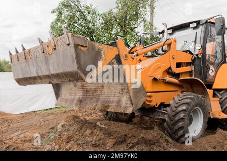 Bagger oder Bulldozer Schaufel flacht den Boden oder Straße in der Industriezone oder Baustelle. Stockfoto