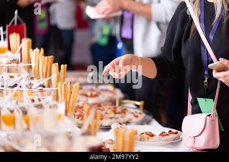 Im Restaurant servieren sich Leute mit Häppchen. Buffetkonzept. Stockfoto