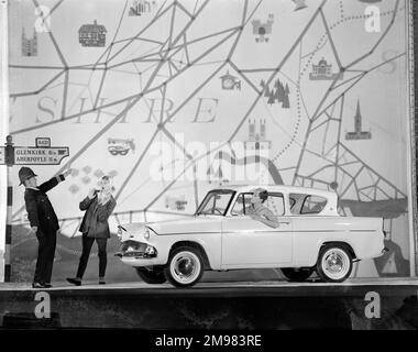 Werbung für Ford Anglia Autos -- männliche und weibliche Modelle posieren (Geraldine Hill, Susan Ingram und Ossie O'Leary). Stockfoto