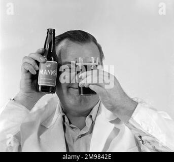 Werbung für Manns Brown Ale... männliches Model, das eine Flasche und ein Glas hält. Stockfoto