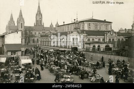 Liepaja, Lettland - Peter's Market (Petera Tirgus) ist seit über 100 Jahren der größte Markt in Liepaja, nachdem er 1910 eröffnet wurde. Der Marktpavillon ist im Zentrum zu sehen, mit der St. Joseph's Cathedral im Hintergrund, einer der vielen Kirchen rund um den Marktplatz. Stockfoto