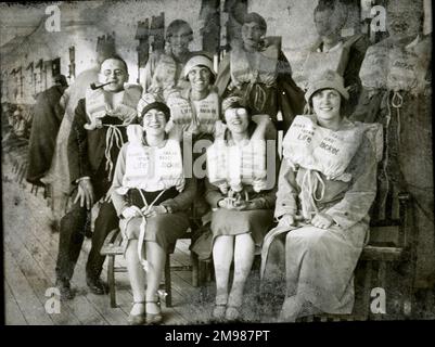 Leute auf dem Deck eines Schiffes, posieren für ein Gruppenfoto in ihren Schwimmwesten. Stockfoto