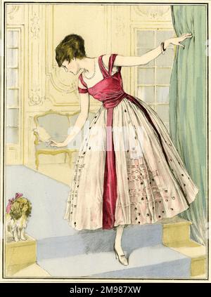 Les Elegances Parisiennes von Paquin -- eine Frau in einem roten und rosa Kleid, die auf ihren Hund herabblickt. Stockfoto